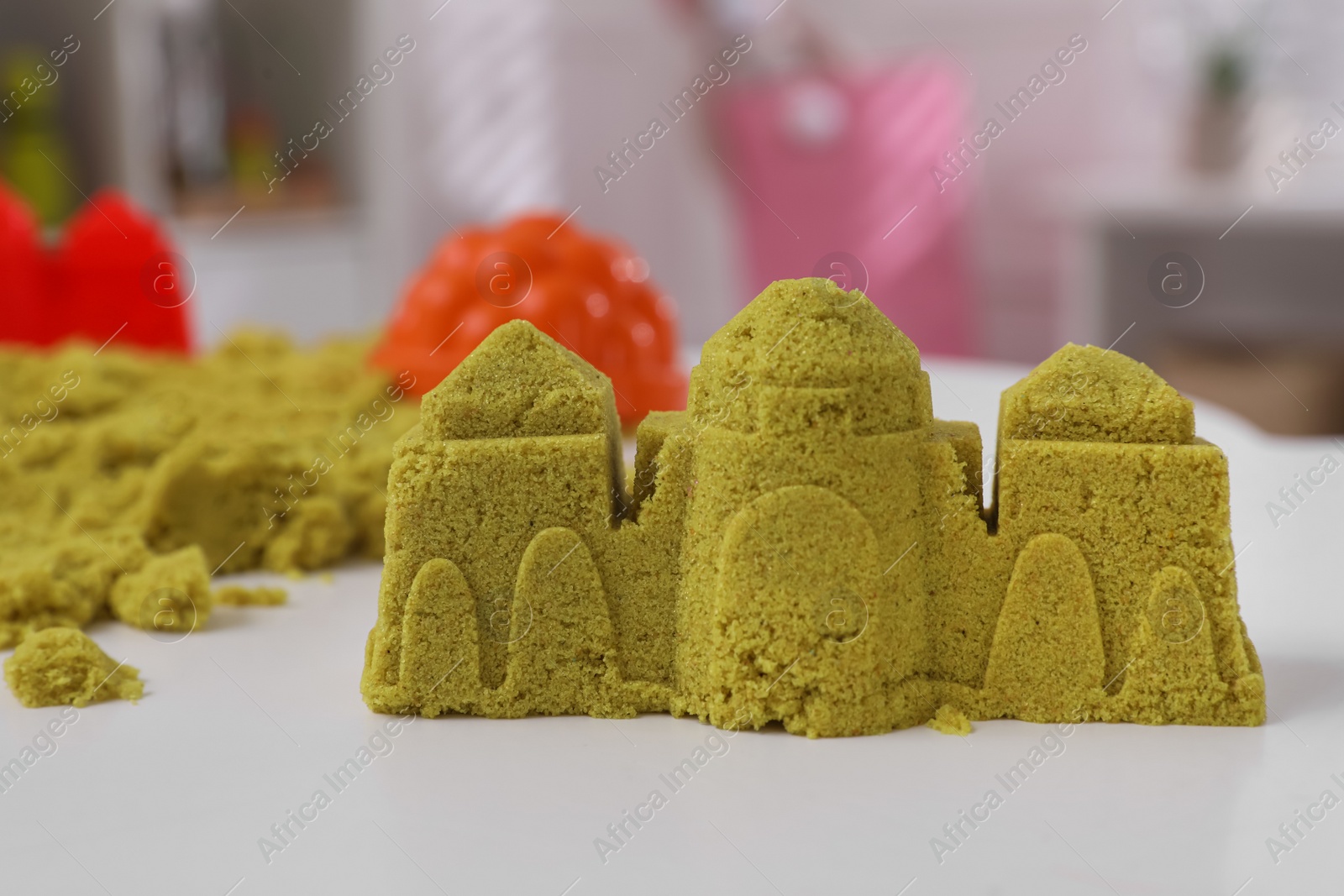 Photo of Castle made of kinetic sand on white table indoors