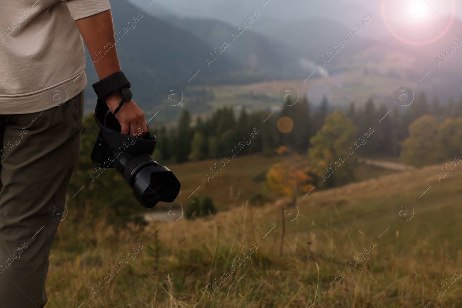 Photo of Professional photographer with modern camera in mountains, closeup. Space for text