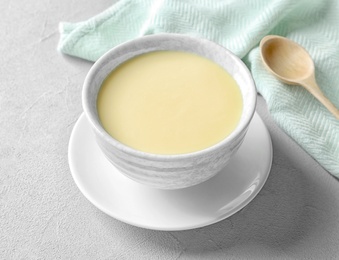 Photo of Bowl with condensed milk served on table. Dairy products