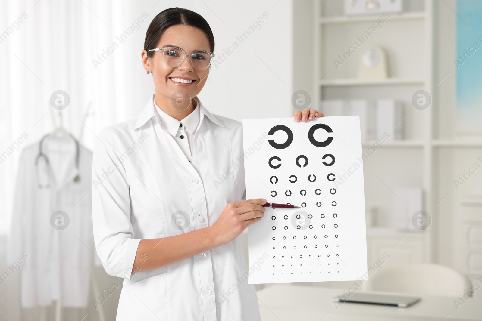 Photo of Ophthalmologist pointing at vision test chart in clinic