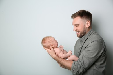 Photo of Father with his newborn son on light grey background