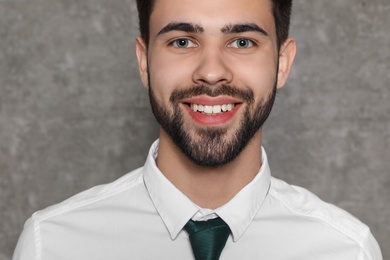 Photo of Portrait of confident businessman smiling on grey background, closeup