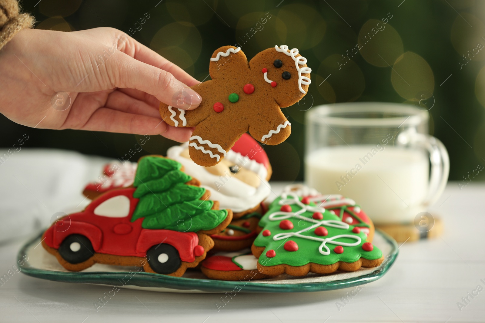Photo of Woman with decorated Christmas cookies at table, closeup