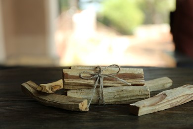 Photo of Palo santo sticks on wooden table, closeup