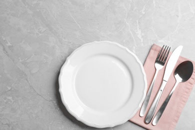 Elegant table setting on grey marble background, flat lay