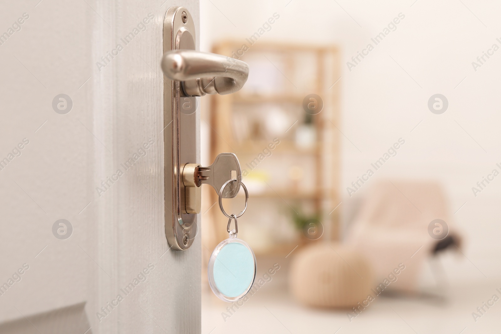 Photo of Open door with key in room, closeup. Space for text