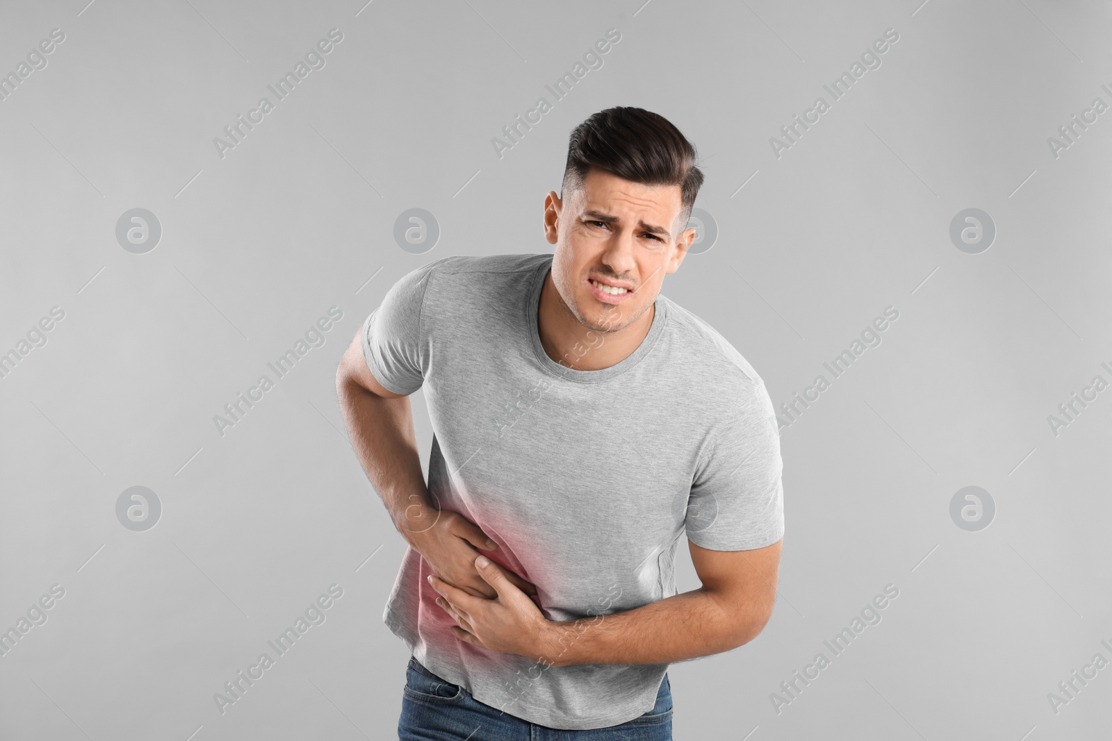 Photo of Man suffering from liver pain on grey background