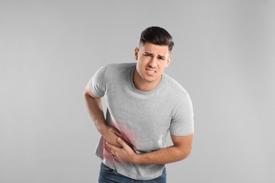 Photo of Man suffering from liver pain on grey background