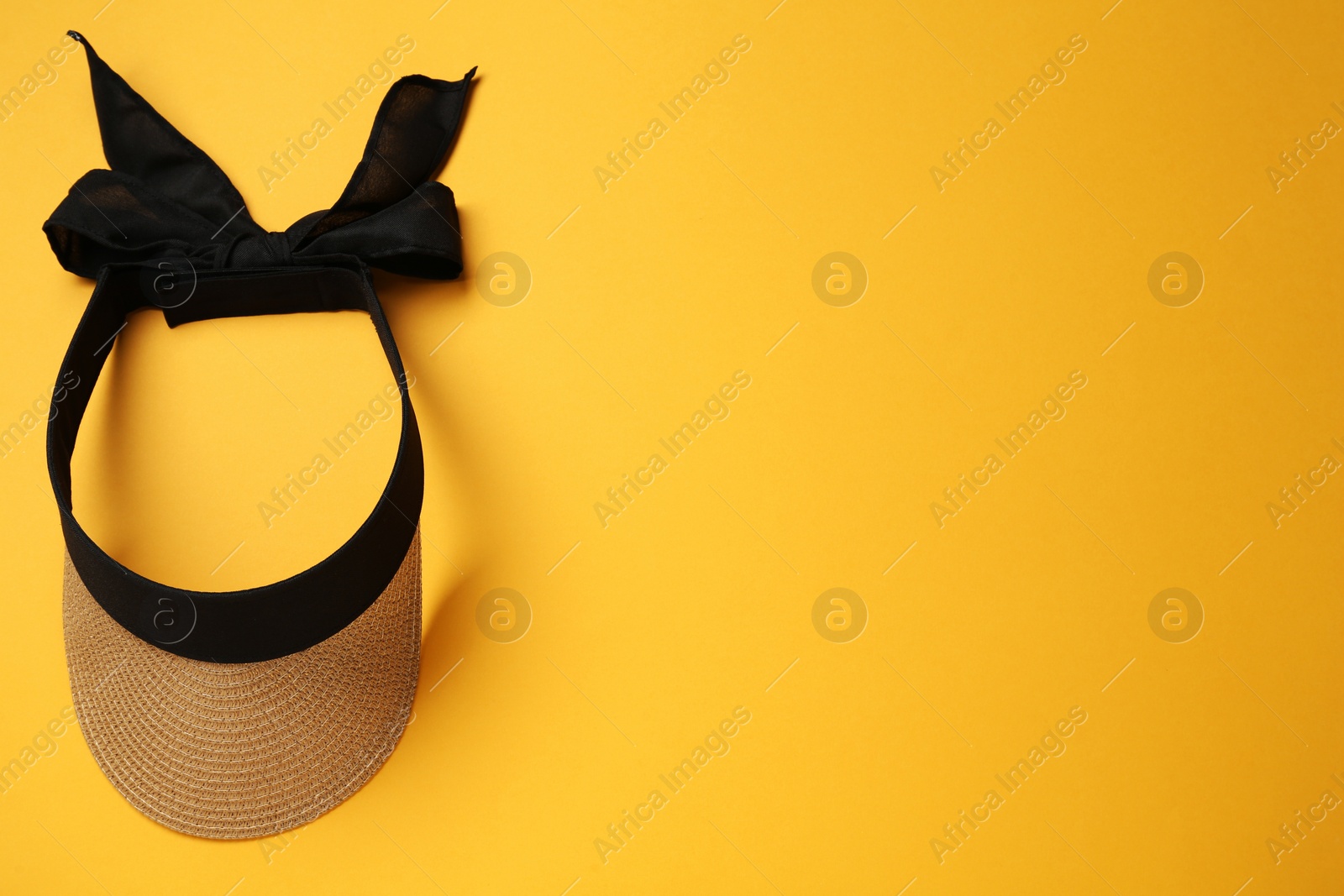 Photo of Sun protective visor cap on yellow background, top view. Space for text