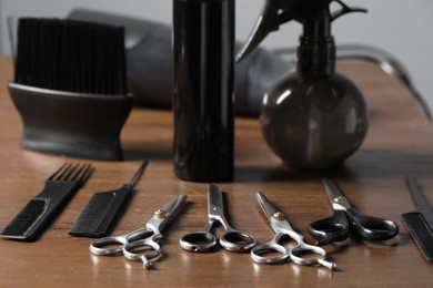 Hairdresser tools. Different scissors and combs on wooden table in salon, closeup
