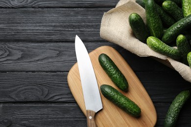 Photo of Fresh ripe cucumbers on dark wooden table, flat lay. Space for text