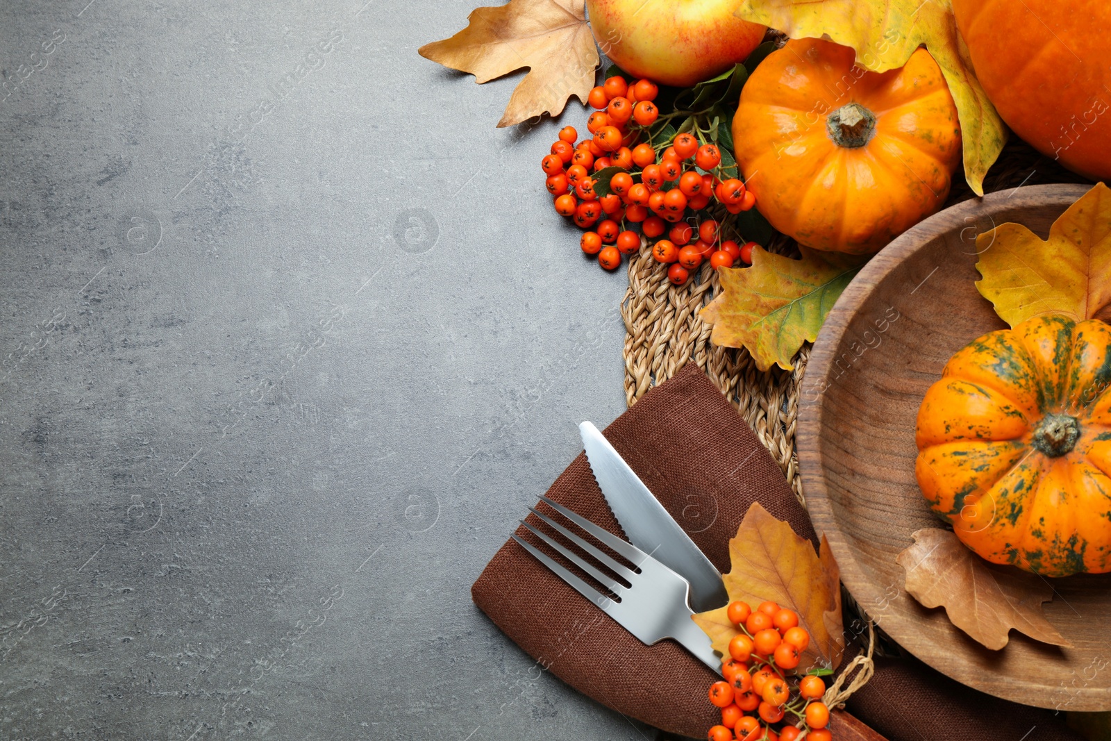 Photo of Flat lay composition with tableware, autumn leaves and vegetables on grey background, space for text. Thanksgiving Day