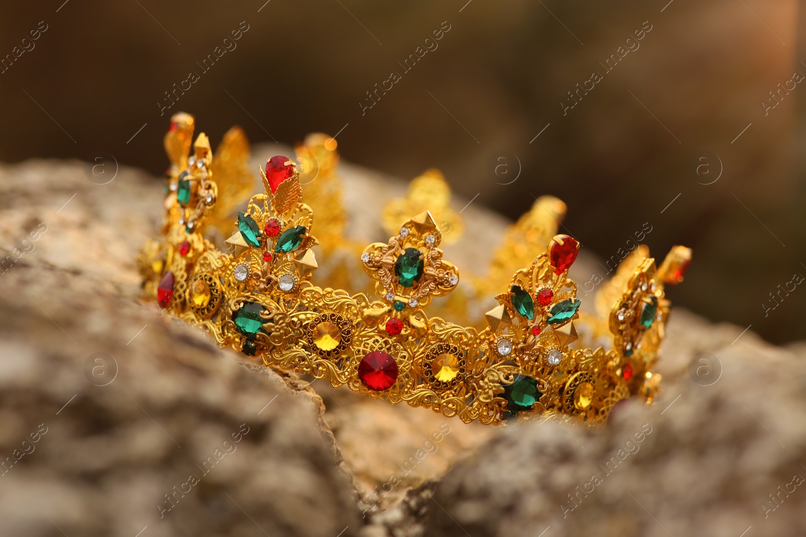 Photo of Beautiful golden crown on stone outdoors, closeup. Fantasy item