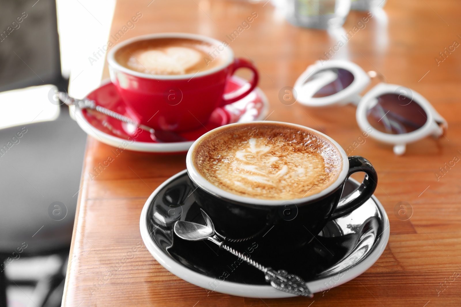 Photo of Cups of fresh aromatic coffee on wooden table