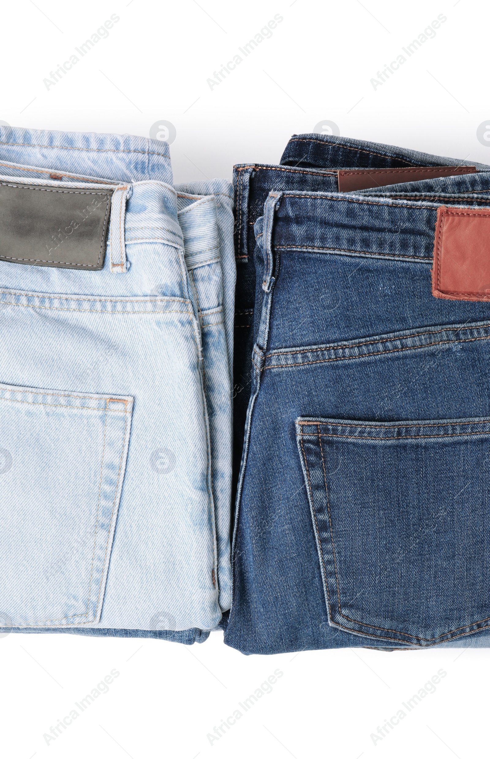 Image of Stacks of different folded jeans isolated on white, top view