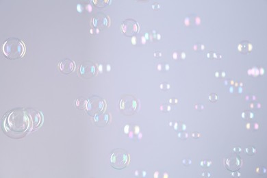 Beautiful transparent soap bubbles on grey background