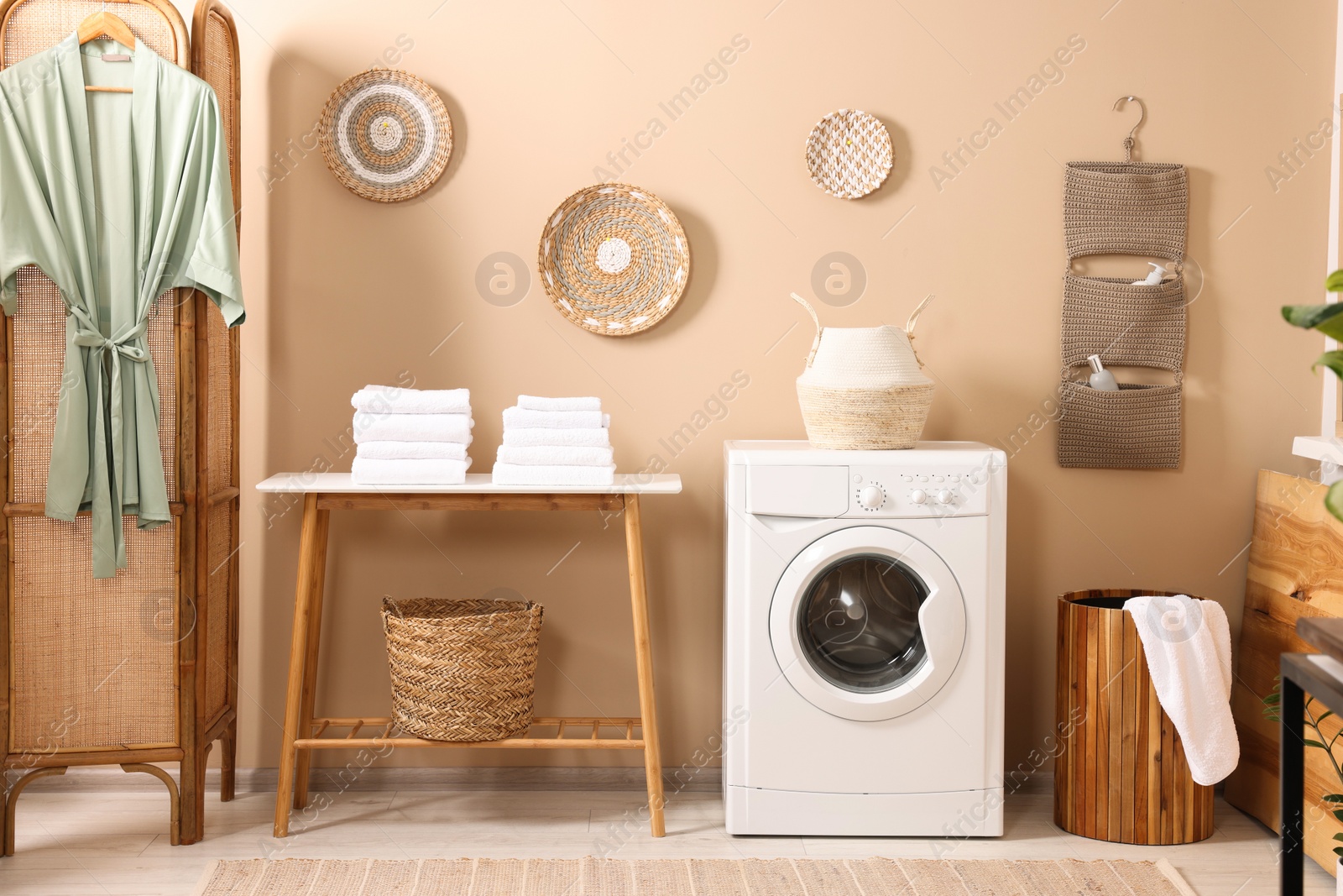 Photo of Stylish laundry room with modern washing machine. Interior design