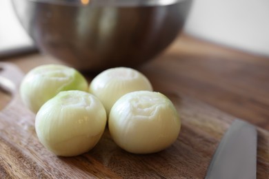 Photo of Fresh ripe onion bulbs on wooden table, closeup. Space for text