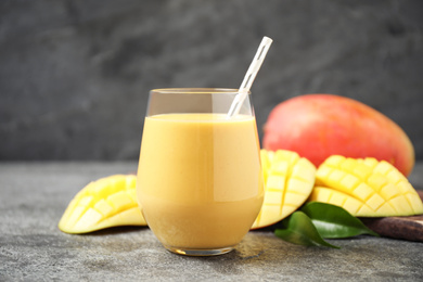 Photo of Fresh delicious mango drink on grey table