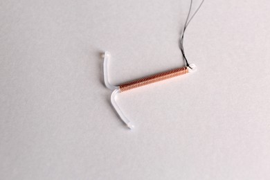 T-shaped intrauterine birth control device on light background
