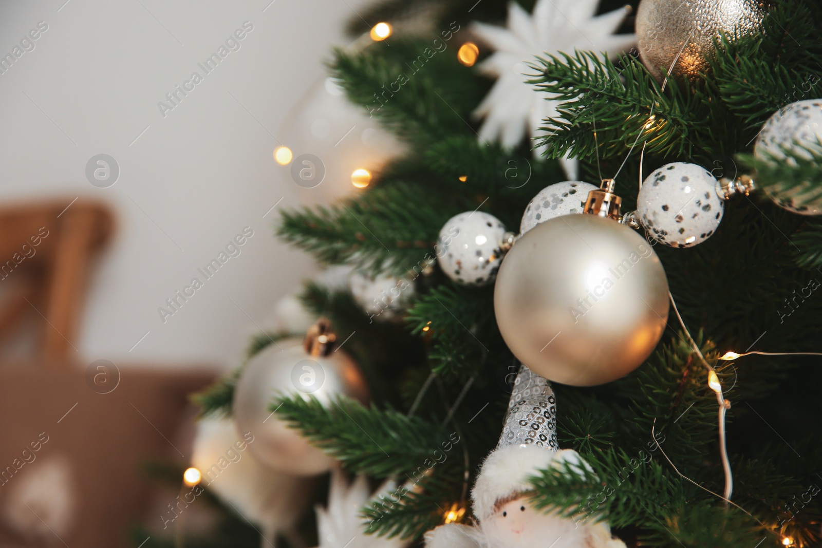 Photo of Beautiful Christmas tree decorated with festive lights and baubles indoors, closeup