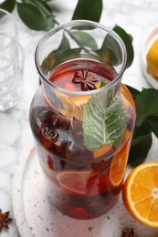 Photo of Delicious punch drink in bottle on white table, closeup