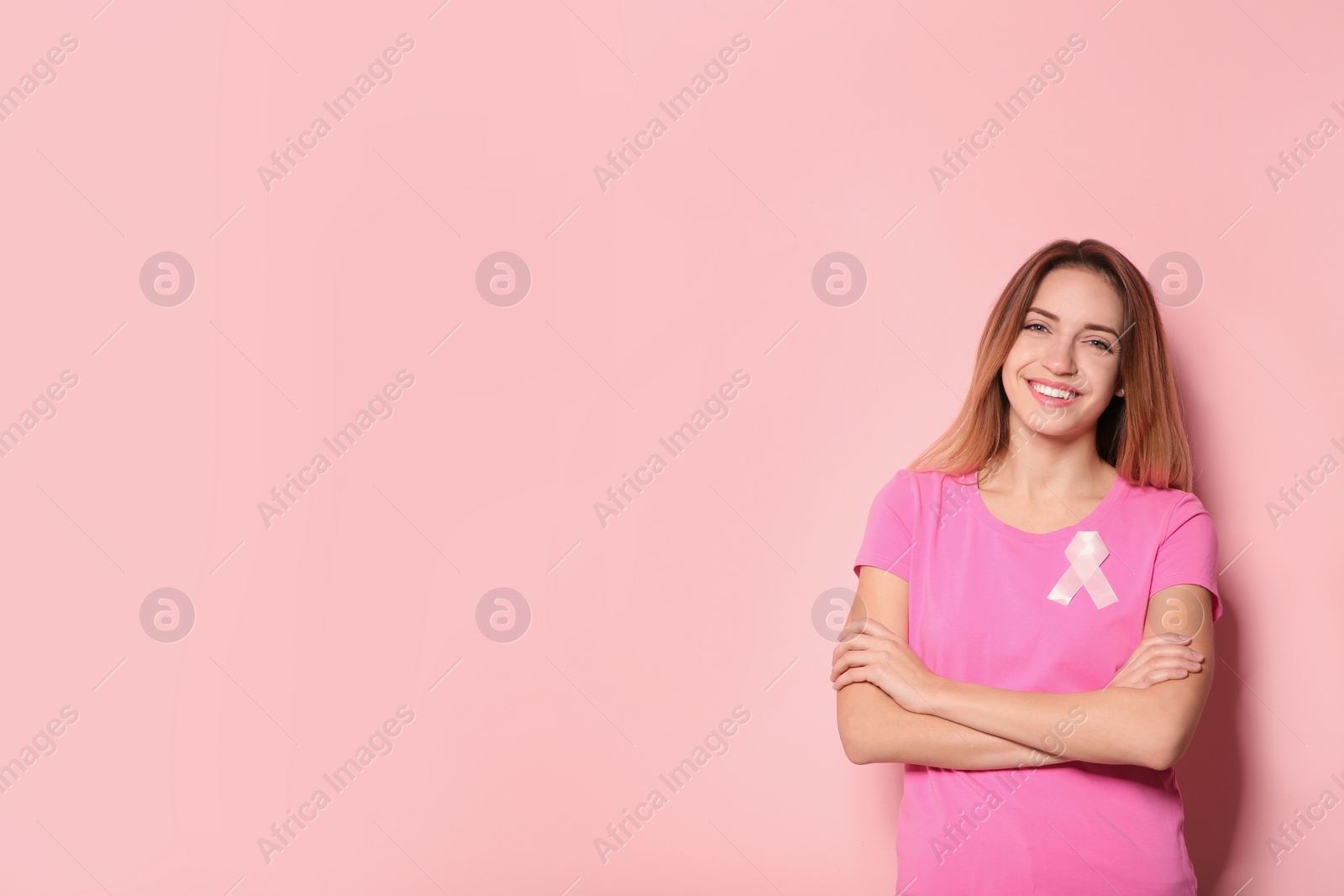 Photo of Woman with silk ribbon and space for text on color background. Breast cancer awareness concept