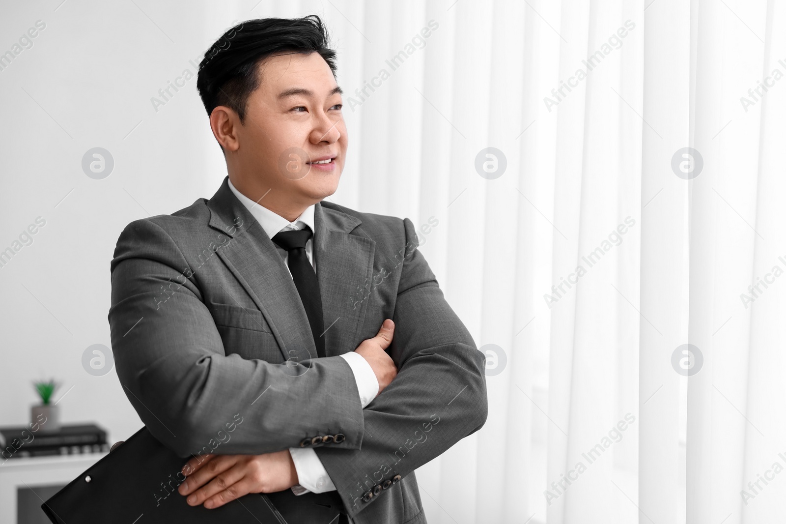 Photo of Portrait of happy notary with clipboard indoors, space for text