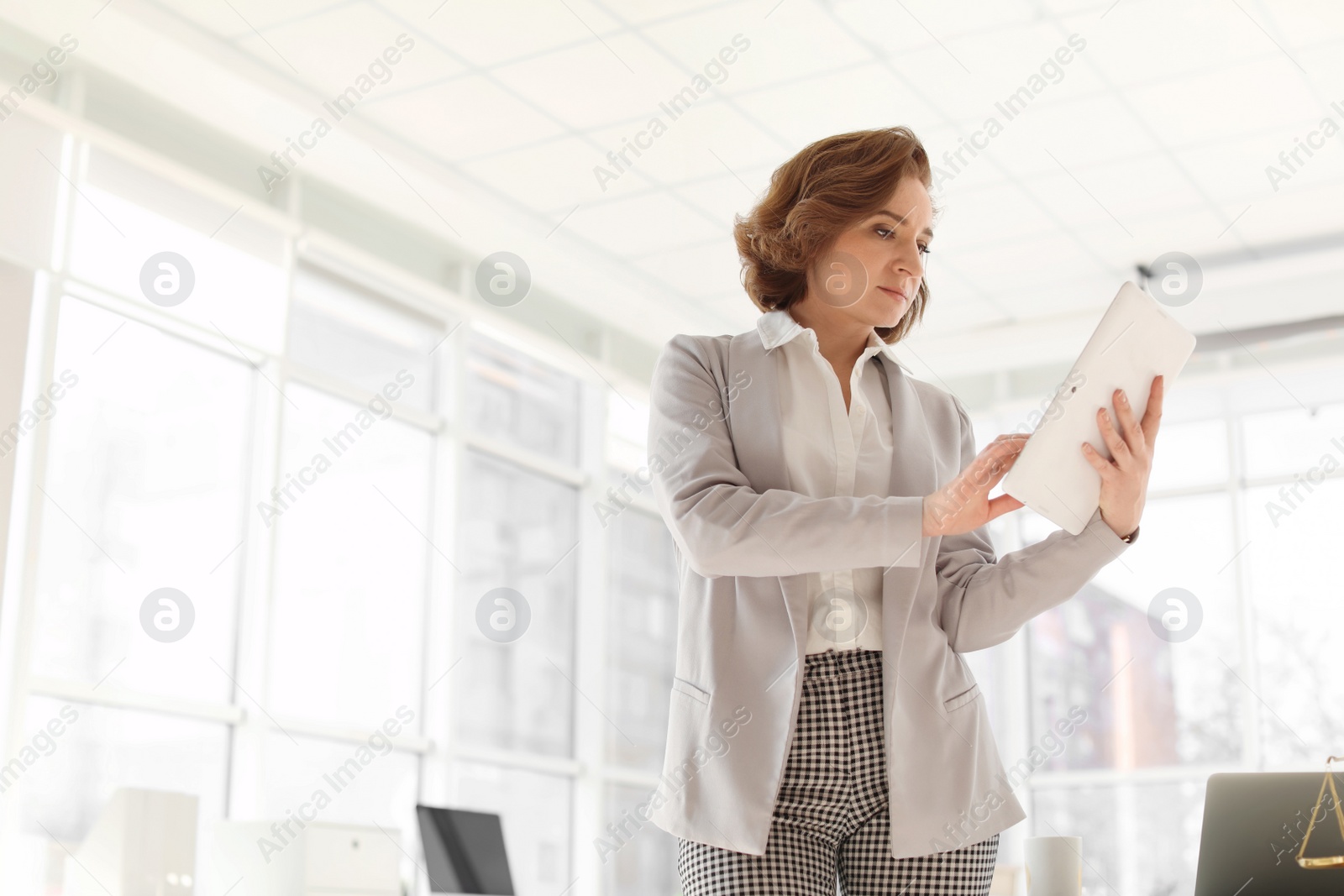 Photo of Female lawyer working with tablet in office