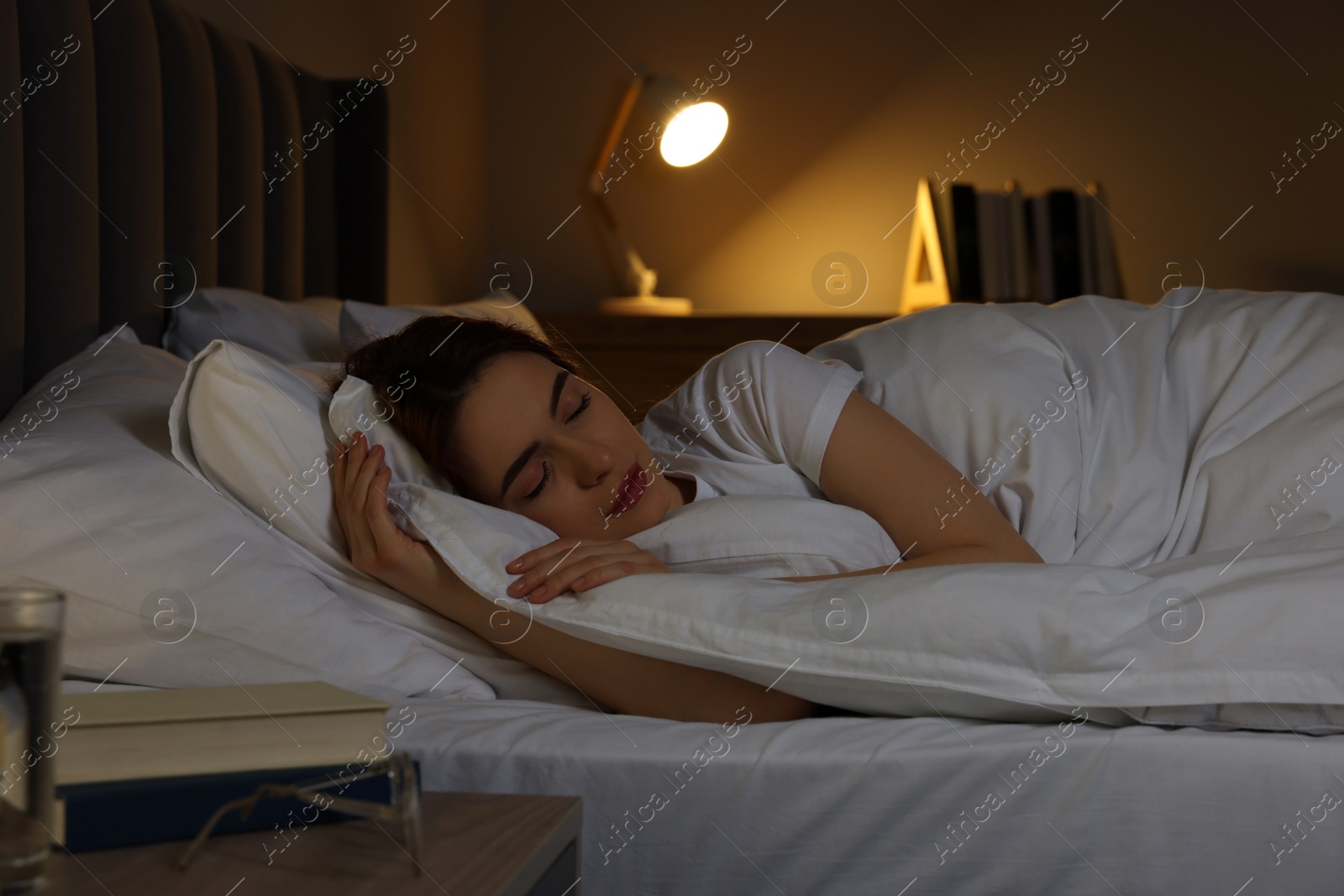 Photo of Beautiful young woman sleeping in bed at night