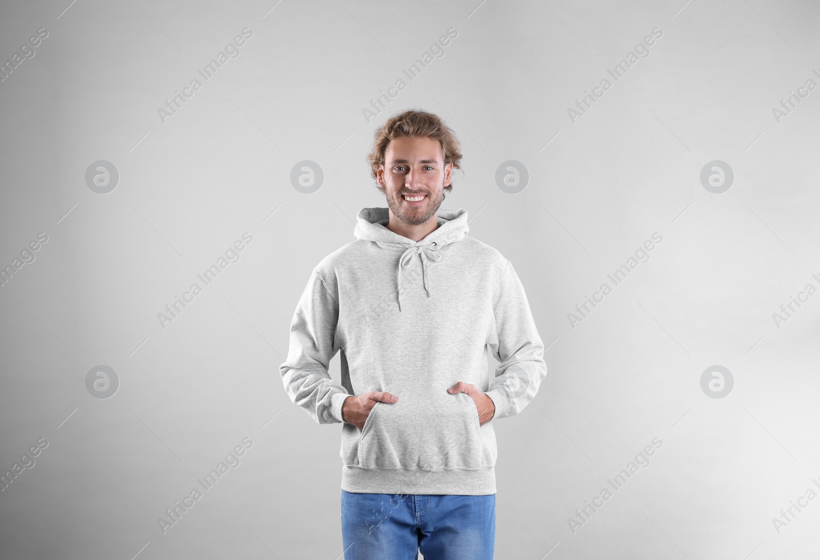 Photo of Portrait of man in hoodie sweater on light background. Space for design