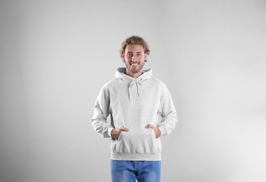 Photo of Portrait of man in hoodie sweater on light background. Space for design