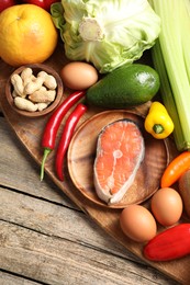 Photo of Healthy meal. Different vegetables and raw salmon on wooden table, flat lay