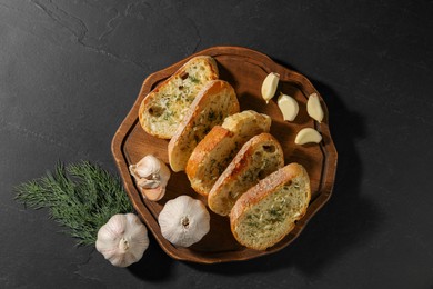 Photo of Tasty baguette with garlic and dill on grey table, top view