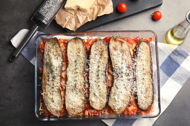 Flat lay composition with baked eggplant, tomatoes and cheese in dishware on table