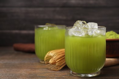 Photo of Glass of delicious iced green matcha tea on wooden table, closeup. Space for text