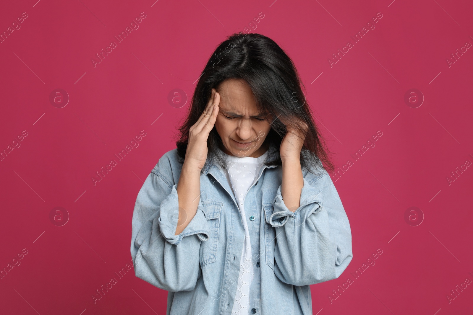 Photo of Mature woman suffering from headache on pink background