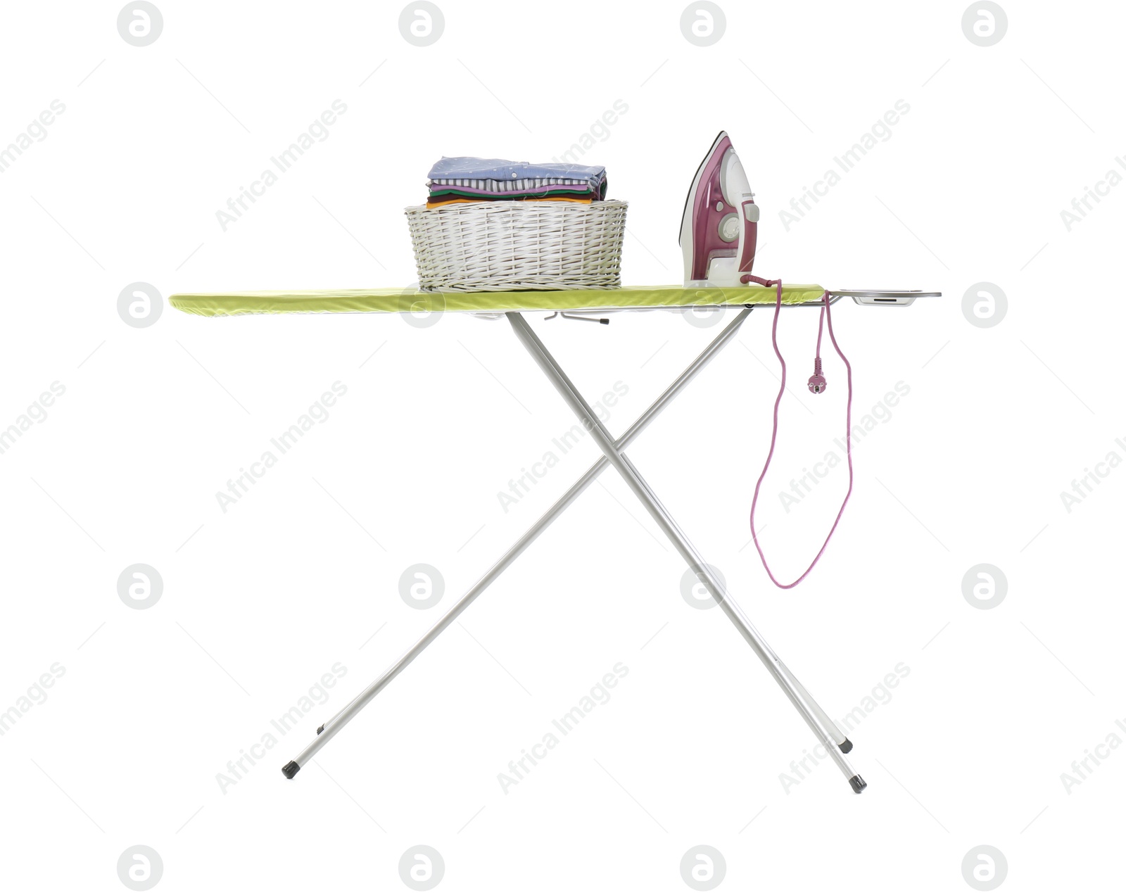 Photo of New modern iron and basket with clean laundry on board against white background