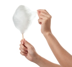 Woman eating yummy cotton candy on white background, closeup