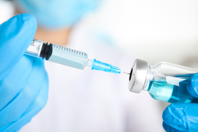 Photo of Doctor filling syringe with medication, closeup. Vaccination and immunization