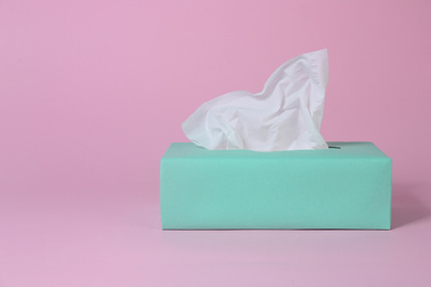 Photo of Box with paper tissues on pink background