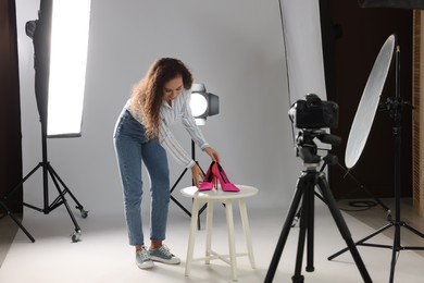 Photo of Professional photographer taking picture of stylish shoes in studio