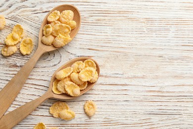 Photo of Tasty corn flakes on white wooden table, flat lay. Space for text