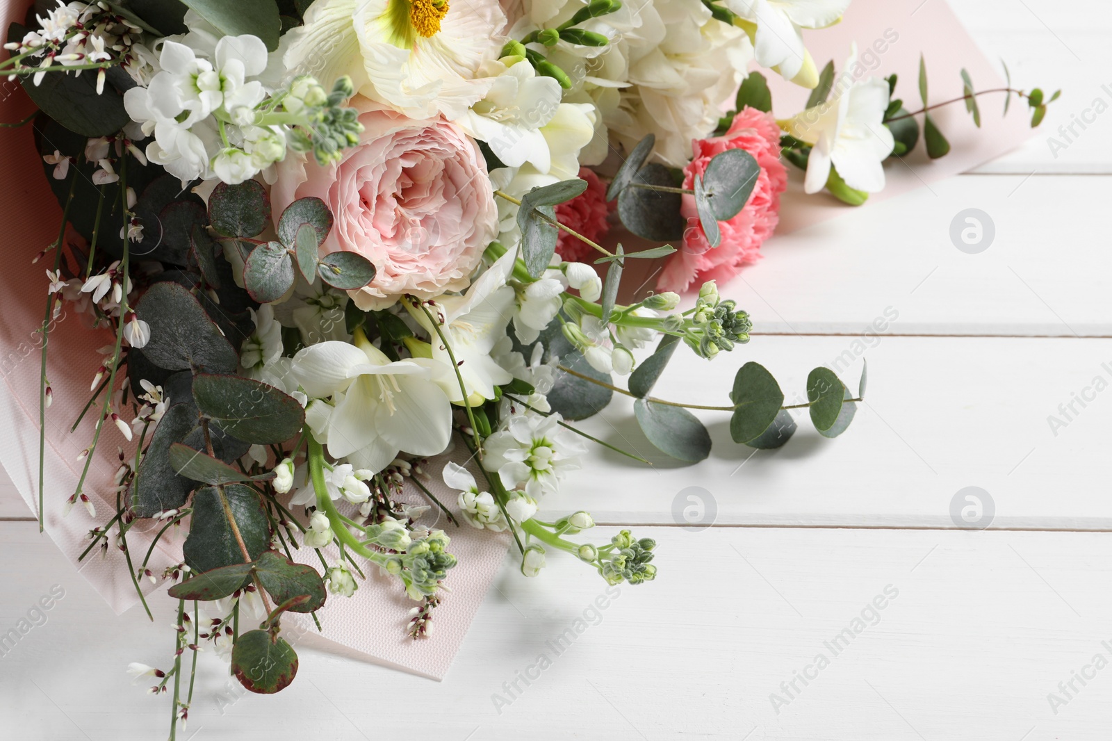 Photo of Bouquet of beautiful flowers on white wooden table, closeup
