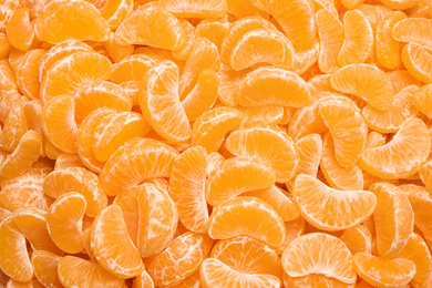 Fresh juicy tangerine segments as background, top view