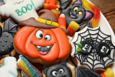 Photo of Tasty cookies and sweets for Halloween party on plate, closeup view
