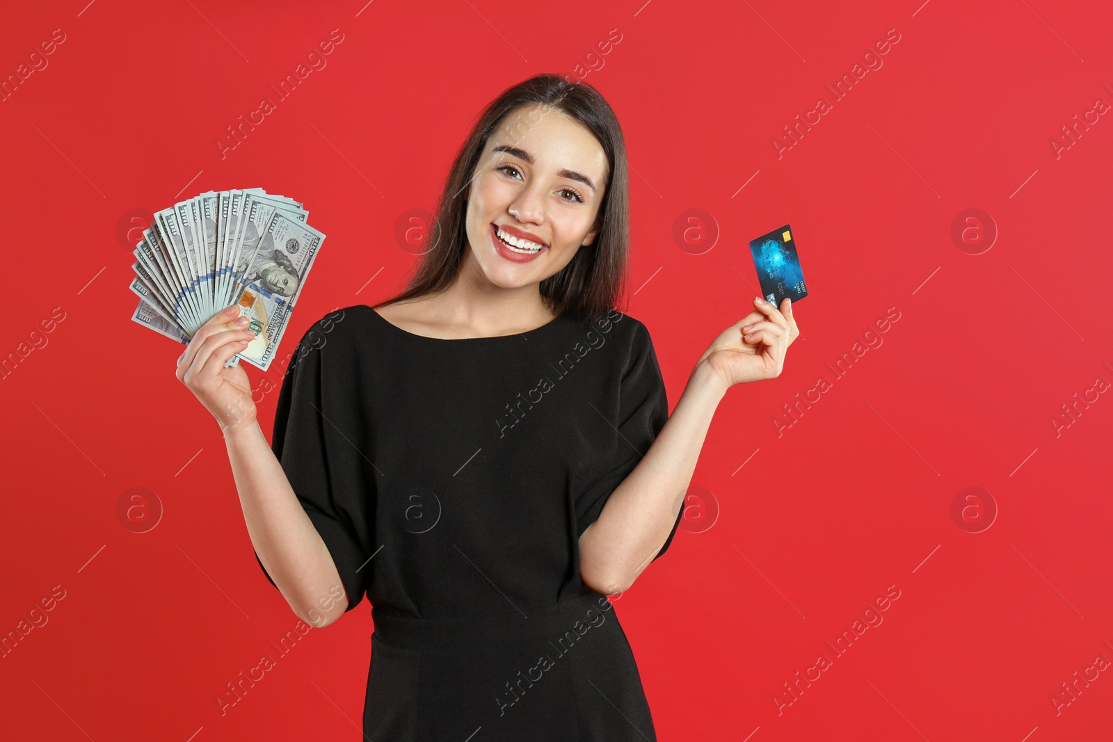 Photo of Young woman with money and credit card on crimson background