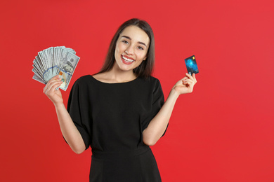 Photo of Young woman with money and credit card on crimson background