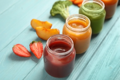 Photo of Healthy baby food and ingredients on light blue wooden table