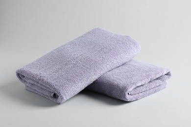 Photo of Fresh fluffy folded towels on grey background